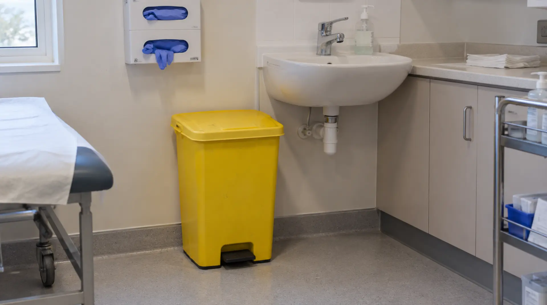 Illustration of a yellow clinical waste bin in an aged-care treatment room